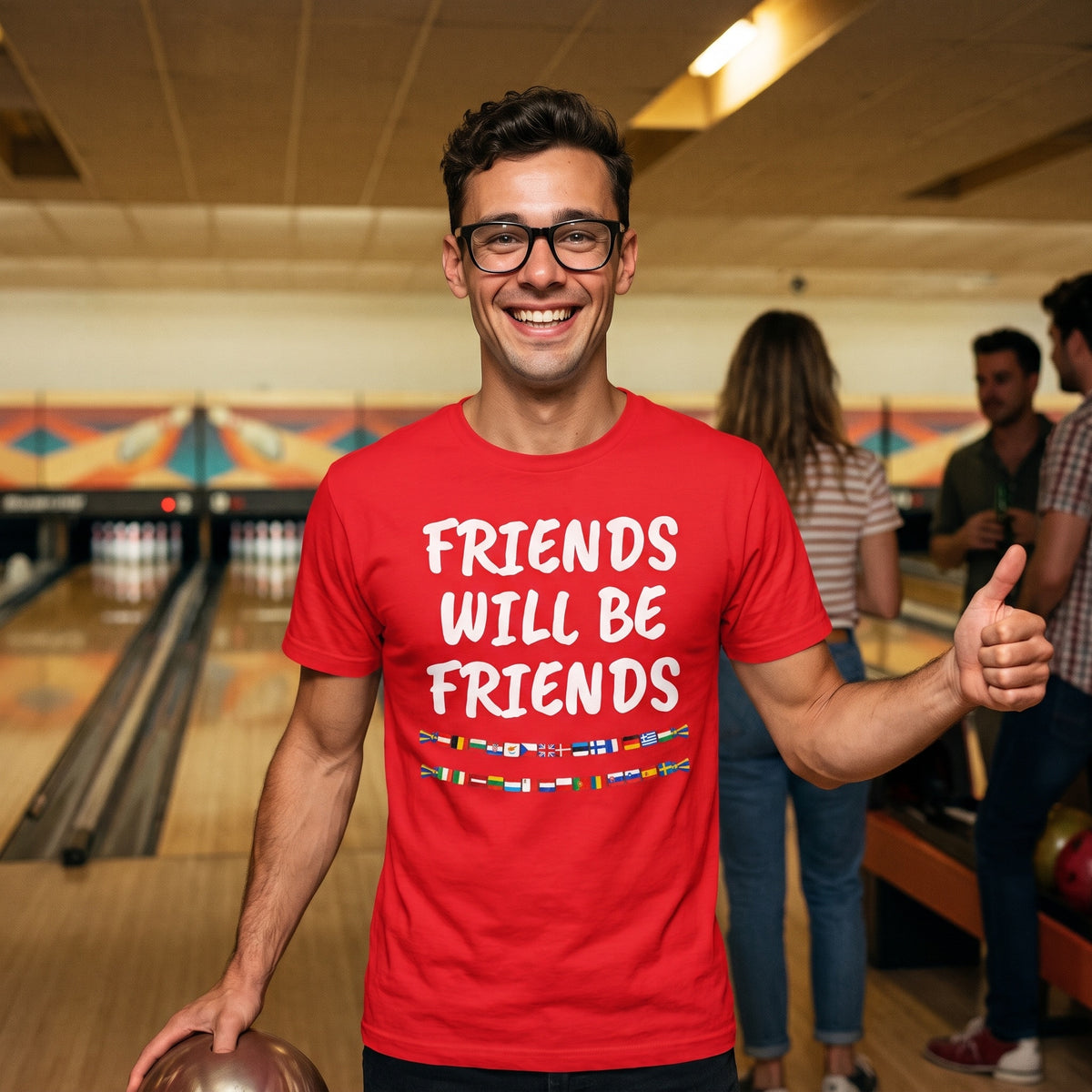 Man at a bowling alley in a red Friends Will Be Friends t-shirt
