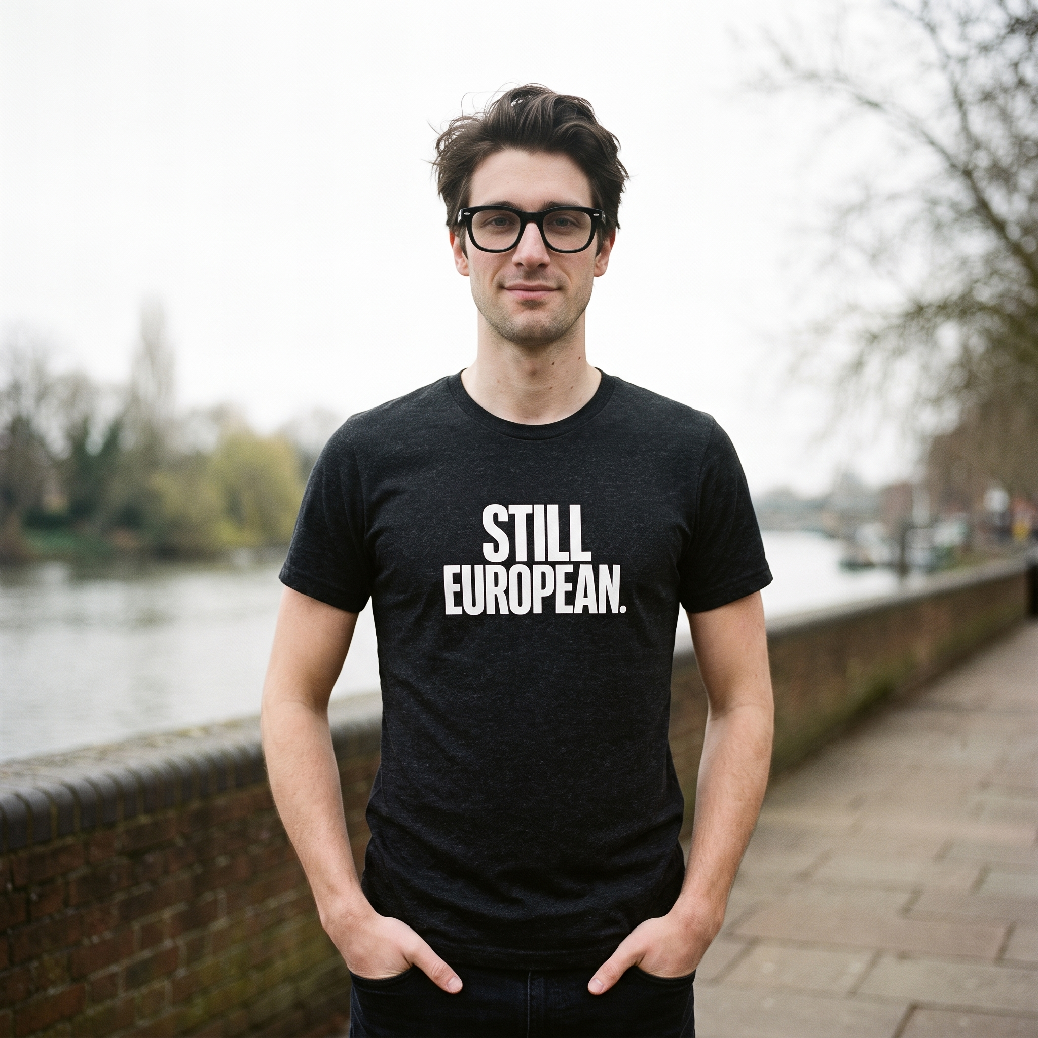 Man in a black heather Still European t-shirt on a riverside walkway, Very Brexit Problems