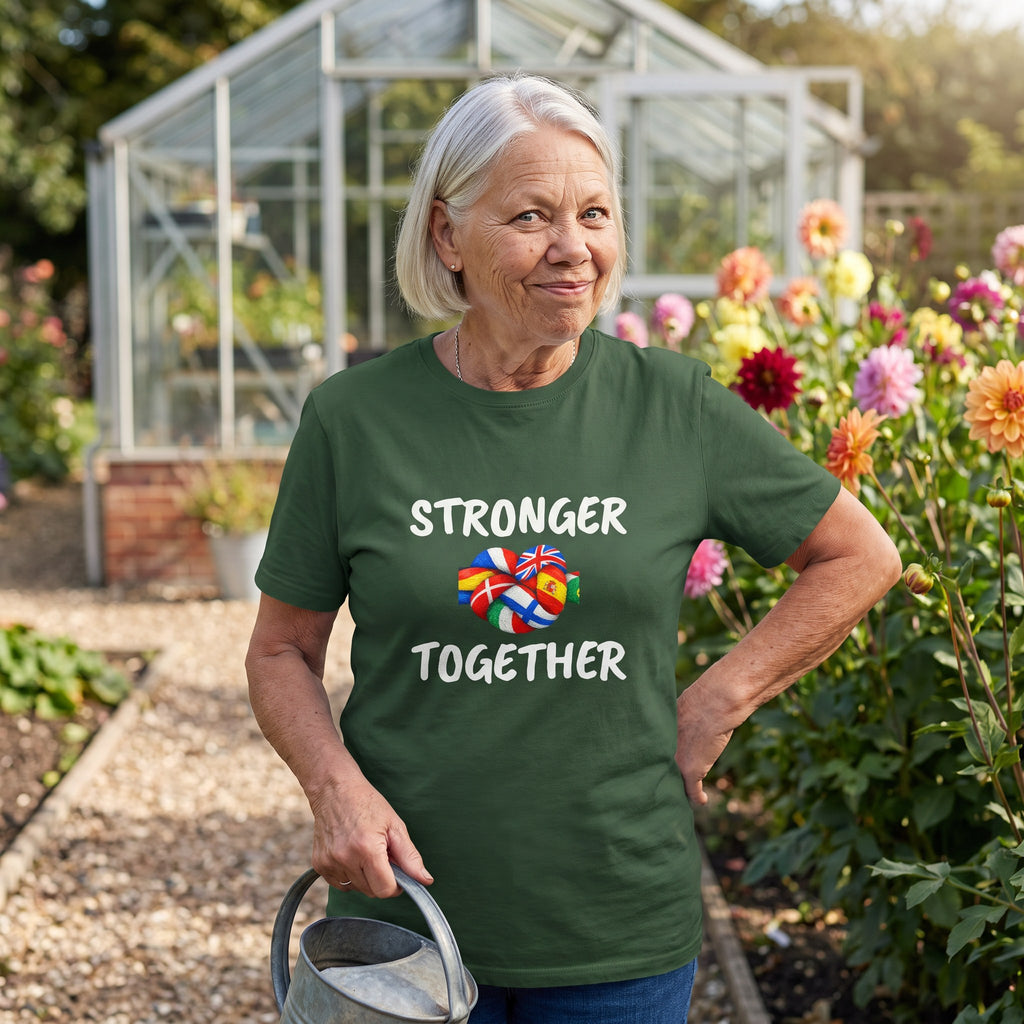 Woman in a cottage garden wearing the forest green Stronger Together t-shirt