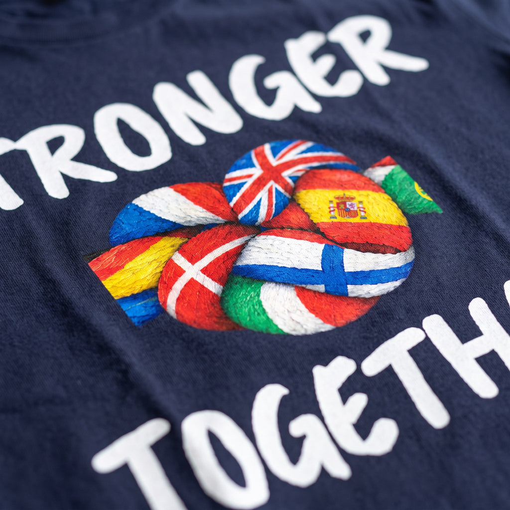 Close-up of the Stronger Together print on a navy t-shirt, a knot of flag-painted rope, showing cotton texture and ink detail