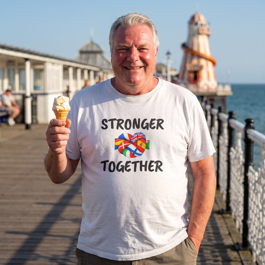 Man with an ice cream on a seaside pier wearing the white Stronger Together t-shirt with black lettering and a knot of European flags