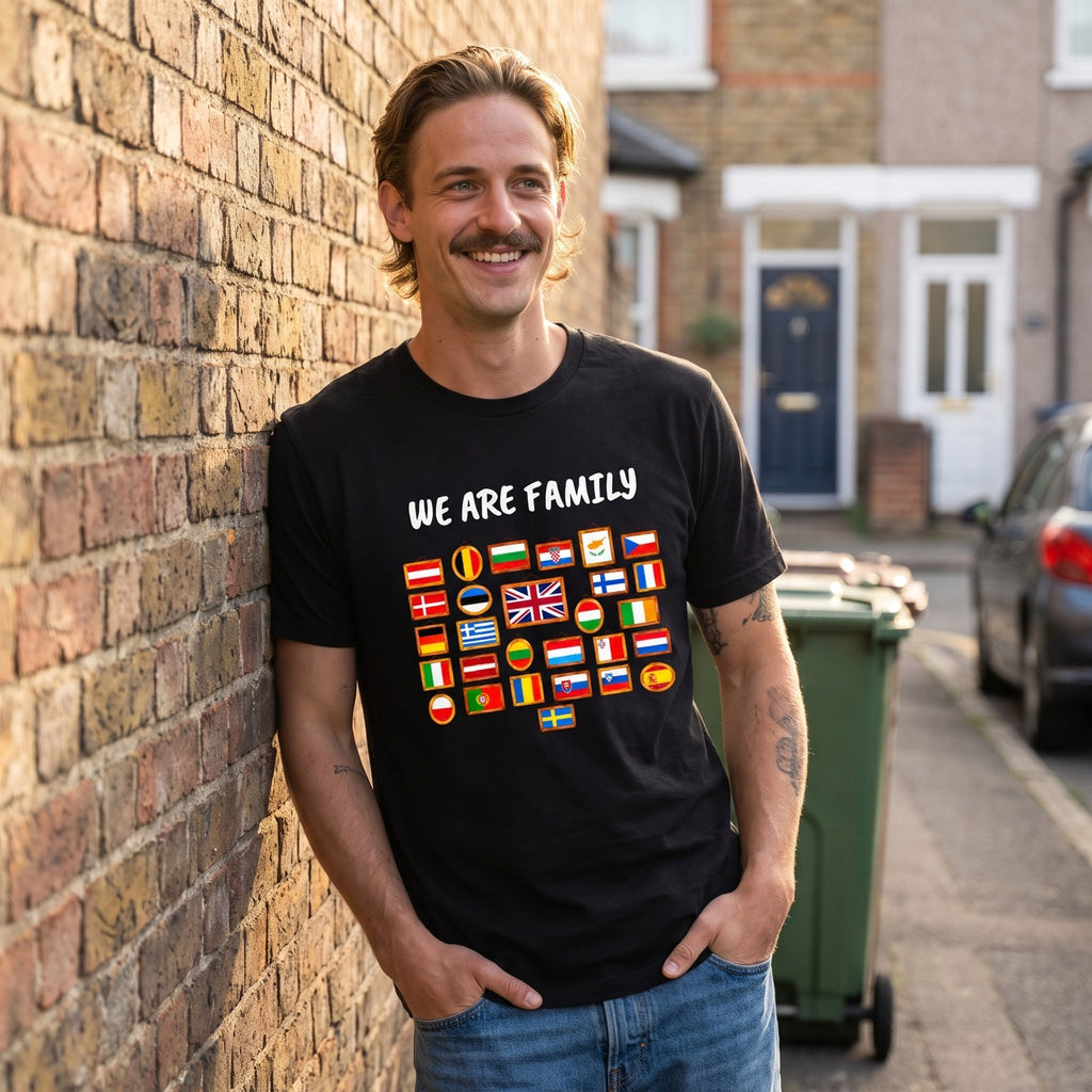 Man leaning on a brick wall on a terrace street wearing the black We Are Family European flags t-shirt, Very Brexit Problems