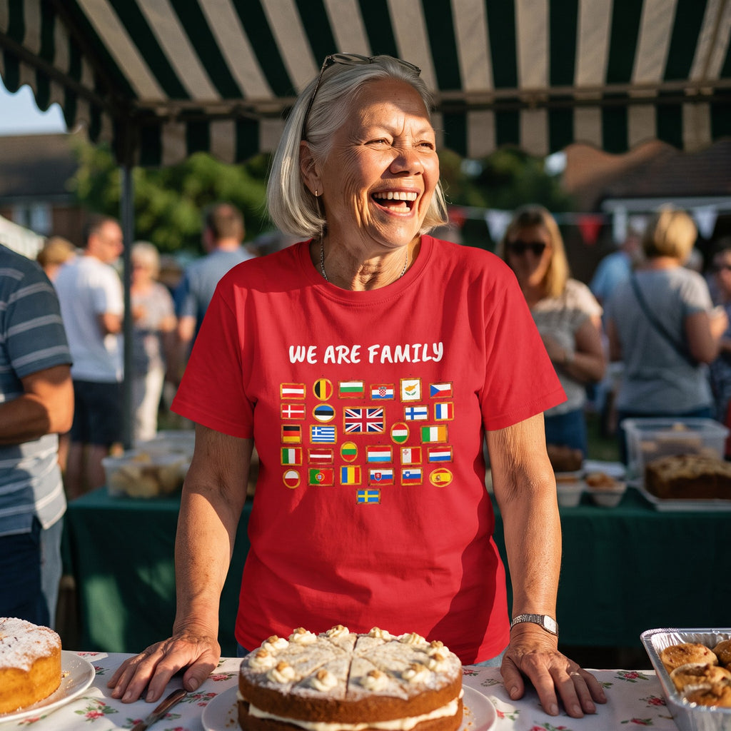 Woman laughing behind a cake stall at a village fete wearing the red We Are Family European flags t-shirt, Very Brexit Problems