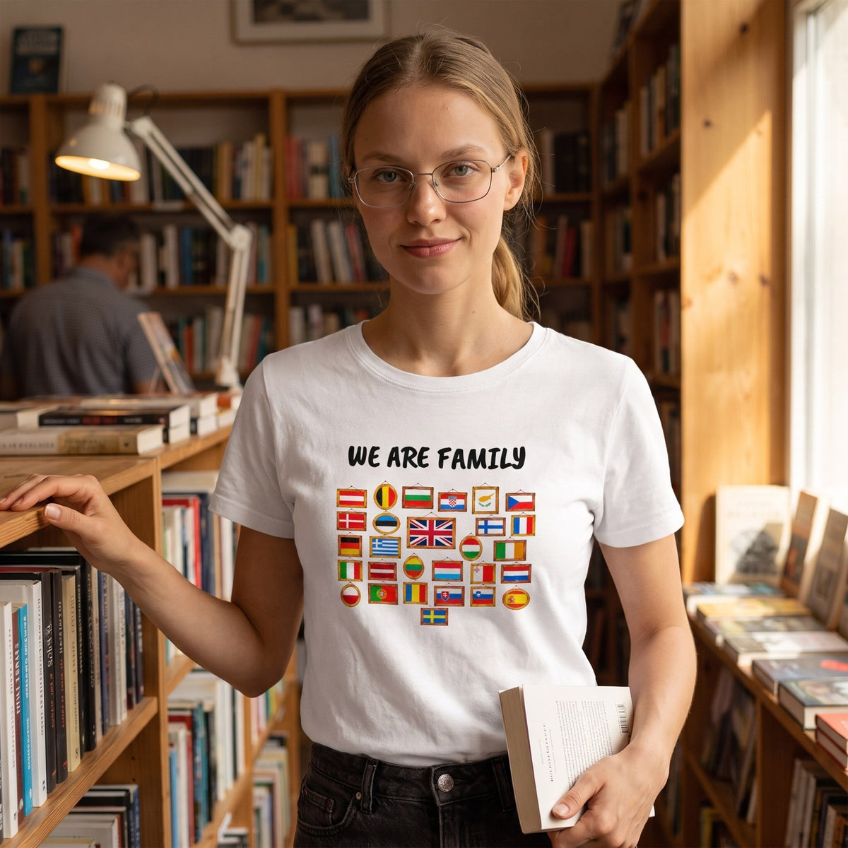 Woman in glasses in an independent bookshop wearing the white We Are Family European flags t-shirt, Very Brexit Problems