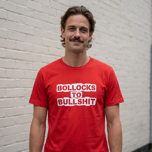 Man in a red Bollocks to Bullshit t-shirt against a brick wall on a British street