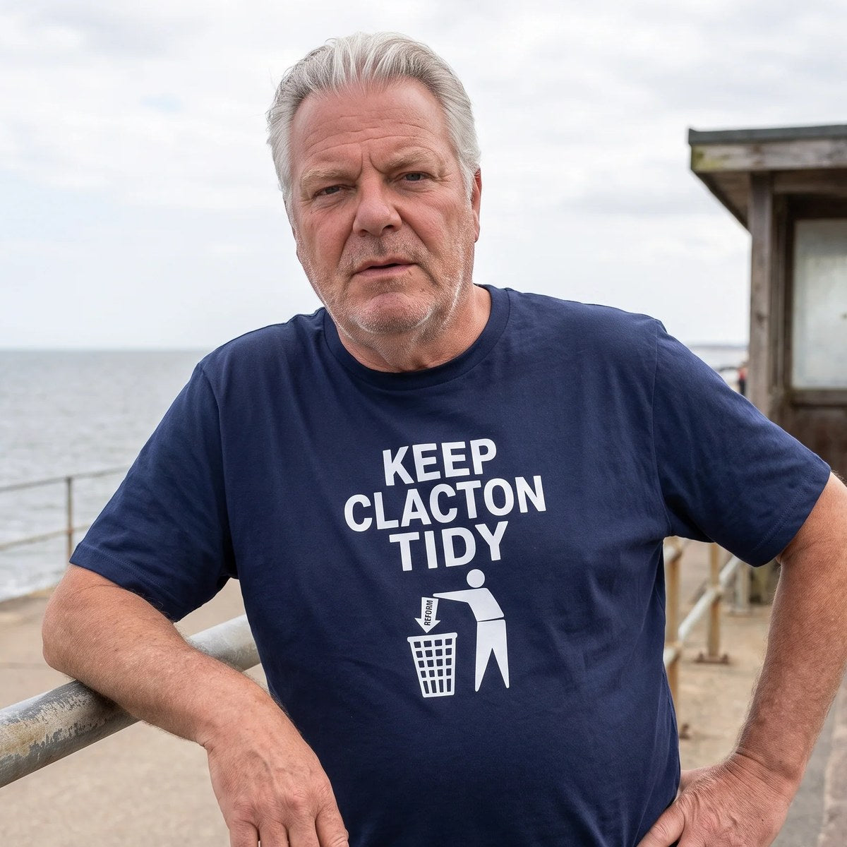 Keep Clacton Tidy t-shirt in navy, worn on Clacton seafront, with the Reform arrow going into the bin